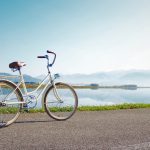gray commuter bike parked on road beside sea