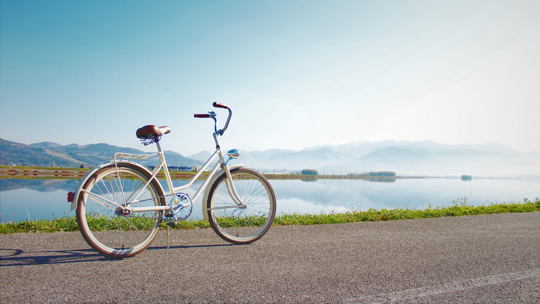 gray commuter bike parked on road beside sea